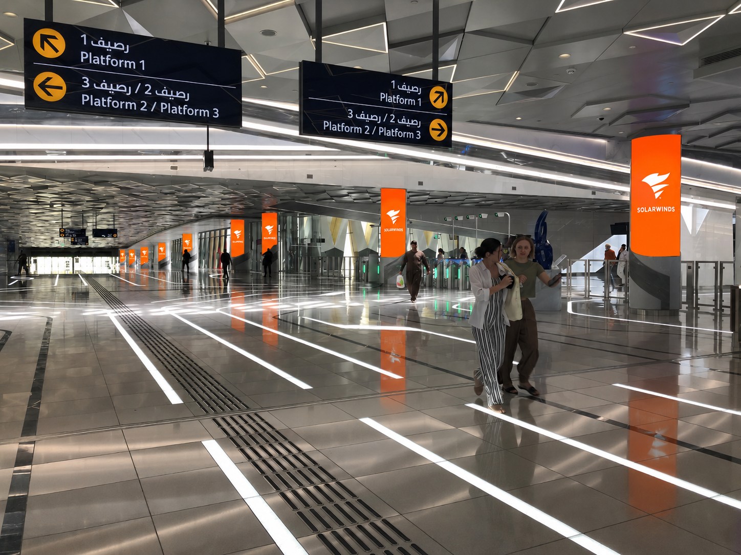 SolarWinds totem columns along the Expo City metro station concourse beside platform wayfinding