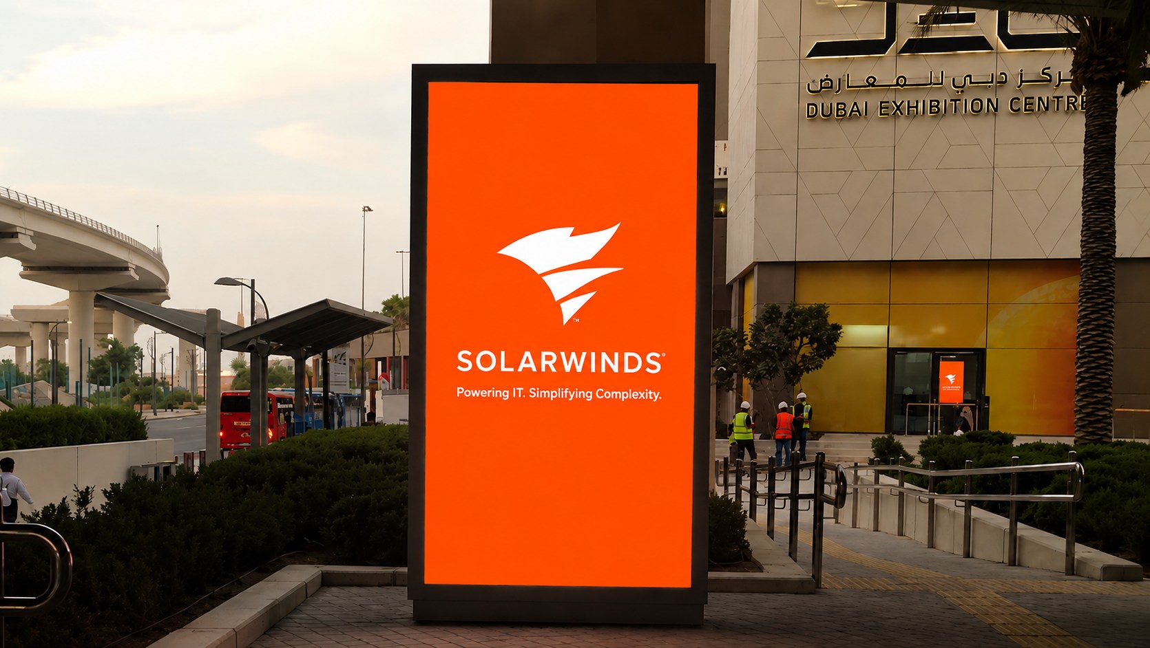 SolarWinds digital totem on the Expo City metro station forecourt with Dubai Exhibition Centre behind